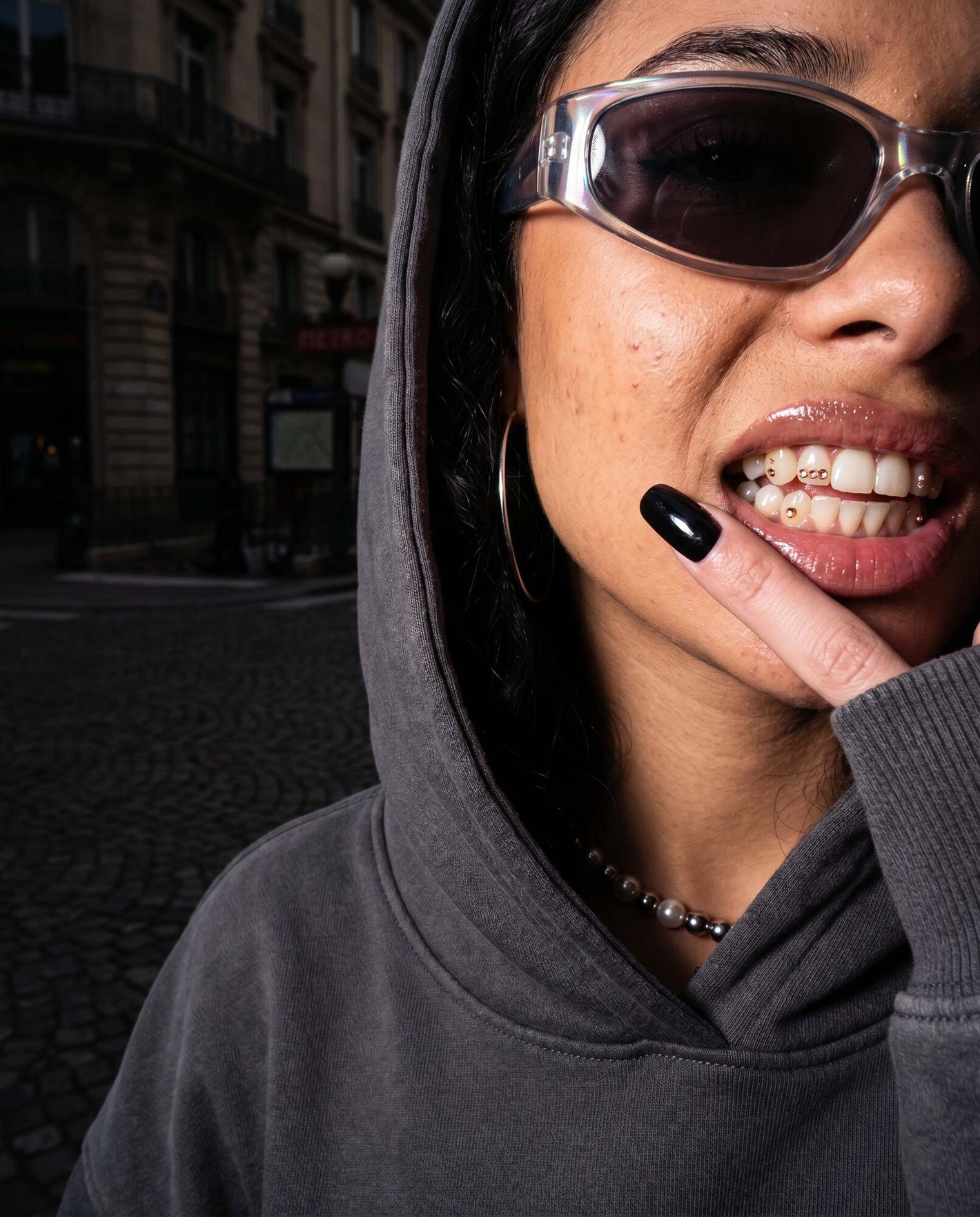 Strass dentaires dorés en look streetwear dans une rue pavée de Paris