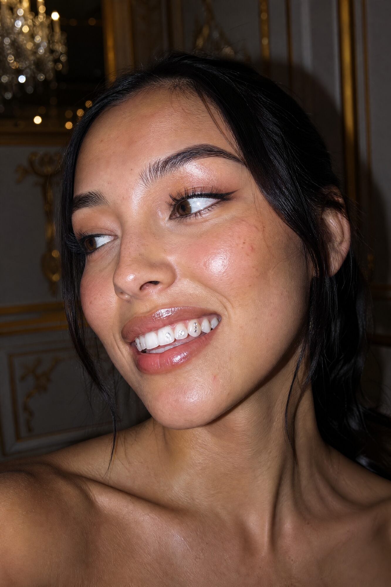 Strass dentaire et sourire dans un intérieur chic et doré